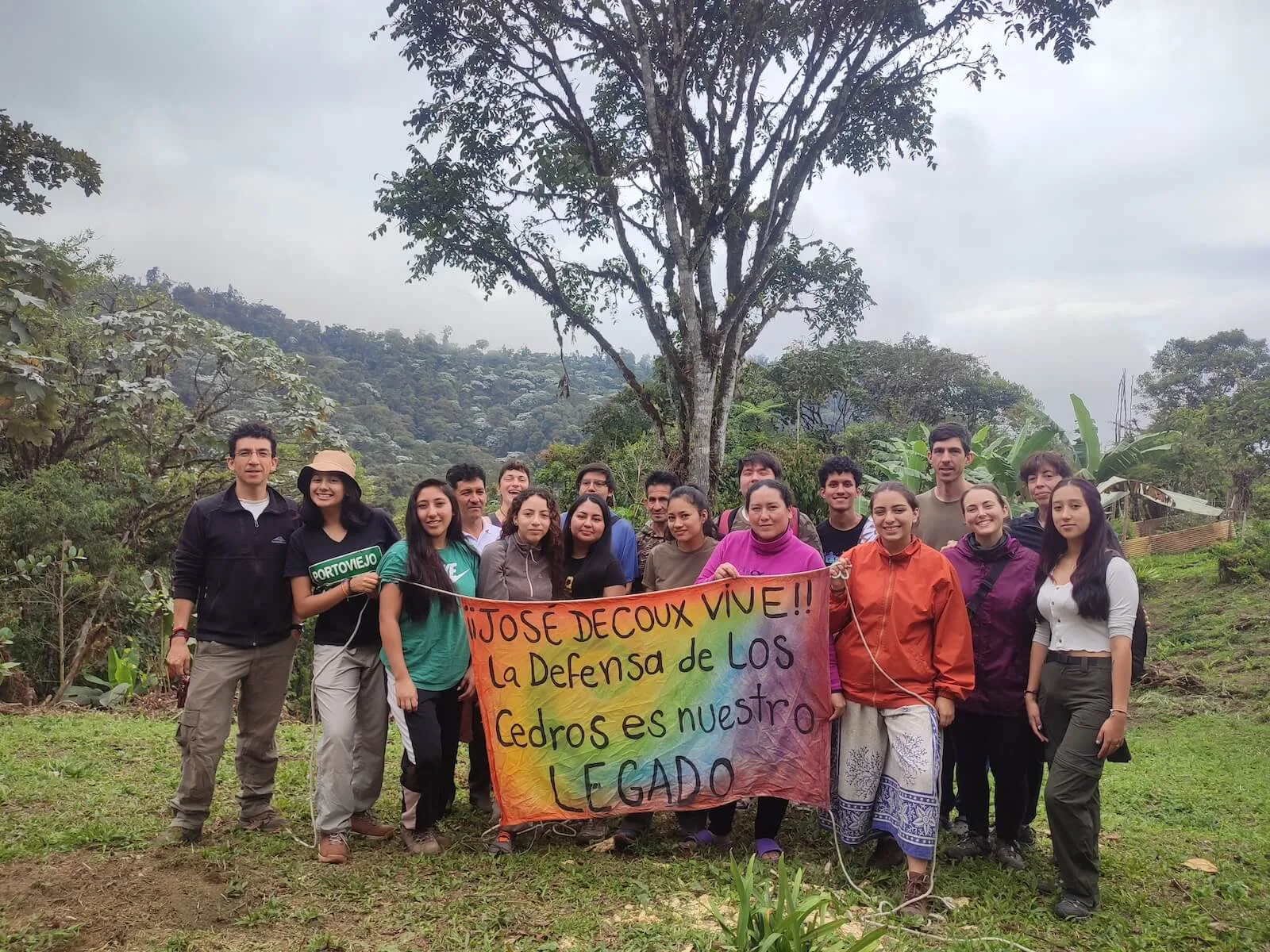 Pontifical Catholic University of Ecuador students at Los Cedros with Scientific Station staff holding banner describing the cloud forest as Josef DeCoux's legacy