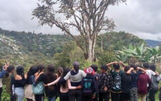 local schoolchildren arm in arm looking at a view of the Los Cedros Protected Forest from the Scientific Station